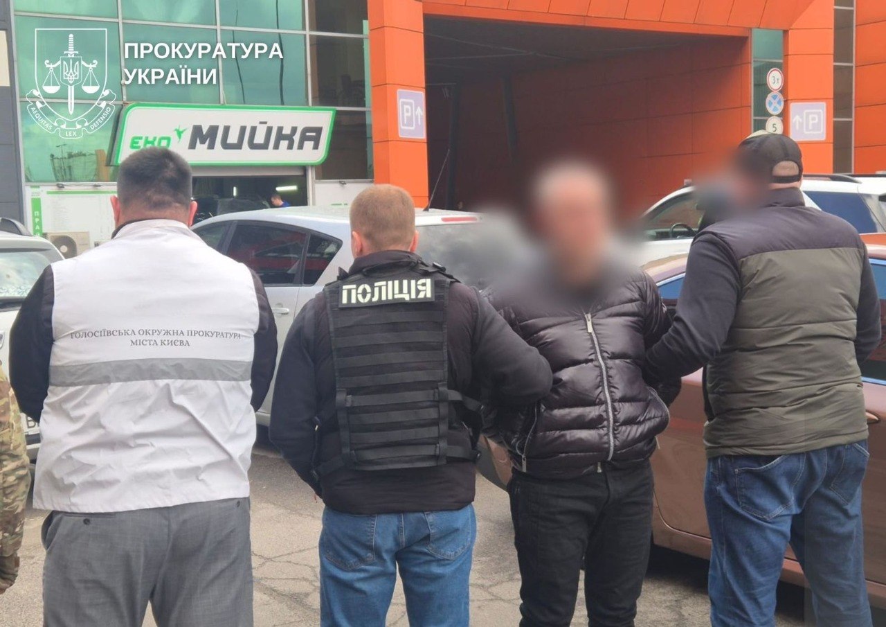 Затриманий стоїть в оточенні правоохоронців