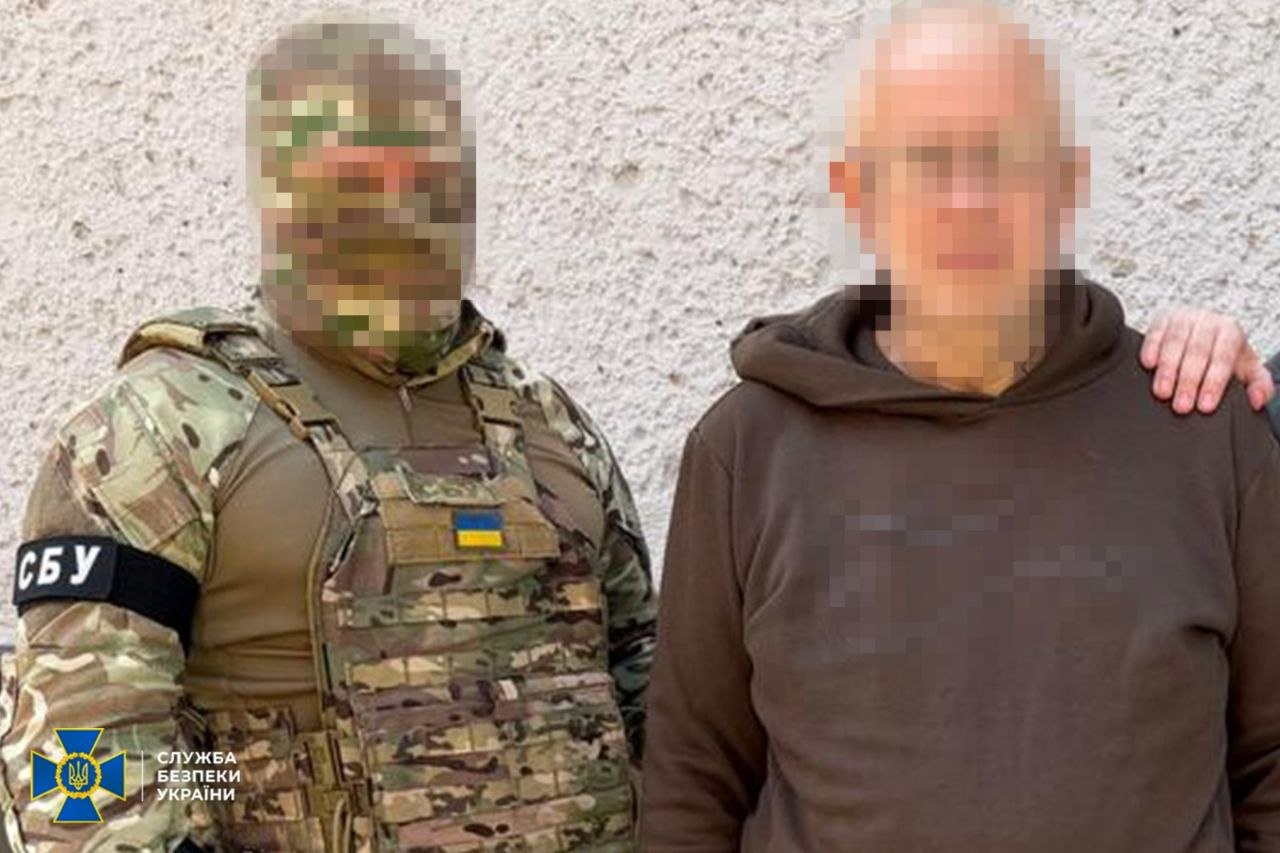 Затриманий стоїть поруч з правоохоронцем