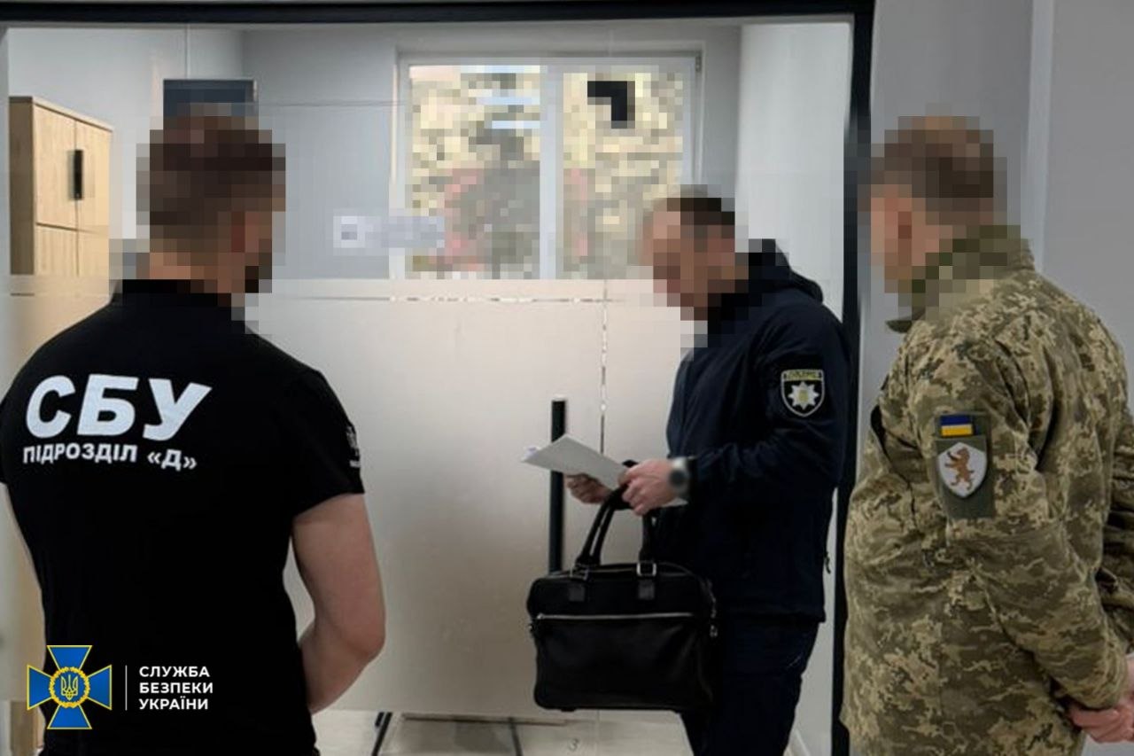 Чоловік щось читає в оточенні правоохоронців