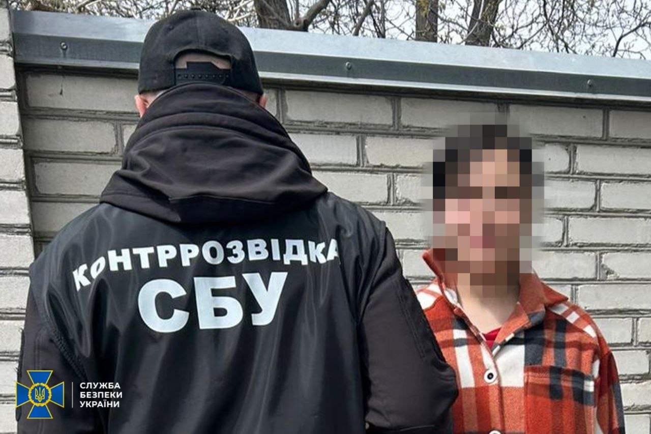 Затримана стоїть обличчям до камери, а правоохоронець - спиною