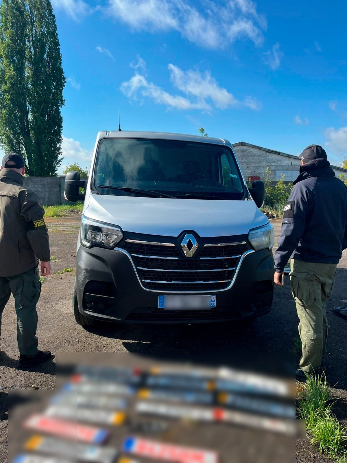 Правоохоронці стоять поряд з білим мікроавтобусом