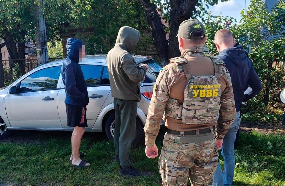 Прикордонник та ще кілька чоловіків стоять біля авто