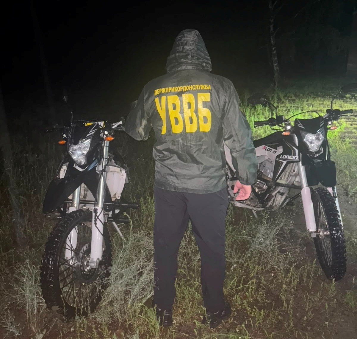 Прикордонник стоїть між двох мотоциклів