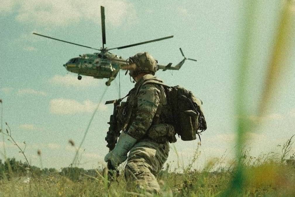 Український воїн на фоні вертольота