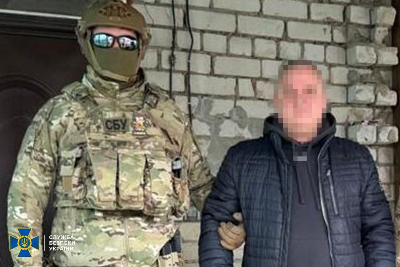 Затриманого тримає під руку правоохоронець