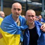 Наші бійці з прапорами на плечах
