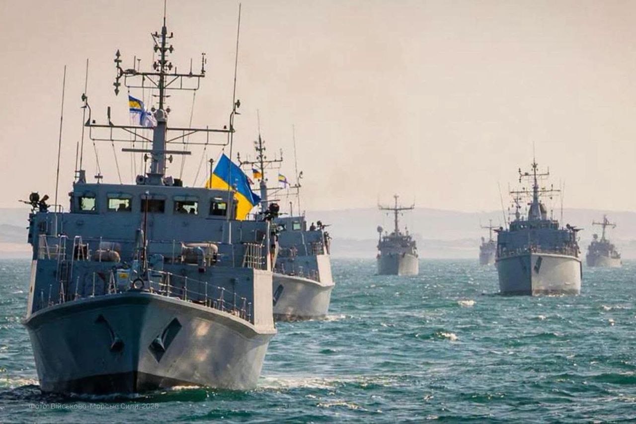 Група військових кораблів рухається морем у кільватерному строю під українськими прапорами. На передньому плані видно протимінний корабель, за яким прямують інші судна з’єднання.