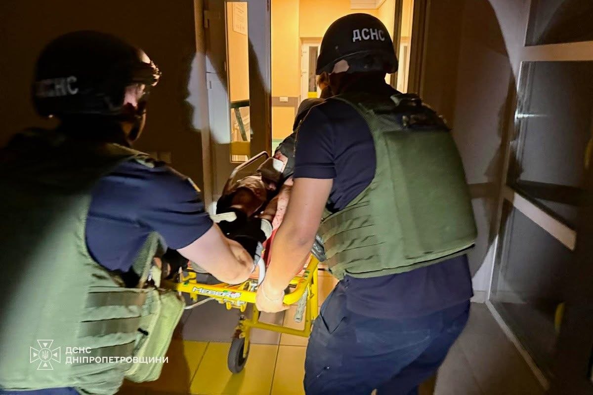 Двоє рятувальників ДСНС везуть на каталці пораненого в лікарні