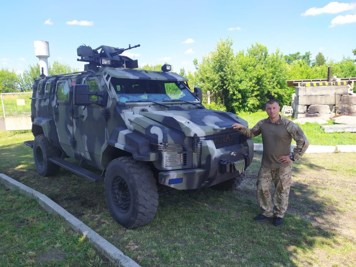 Олександр Очеретнюк біля бойового броньованого автомобіля