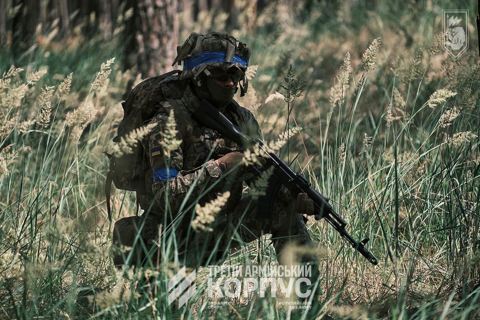 Наш боєць присів зі зброєю