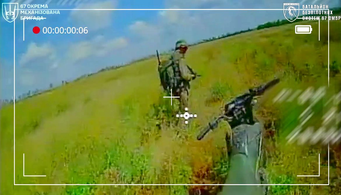 Російський окупант біля мотоцикла у полі