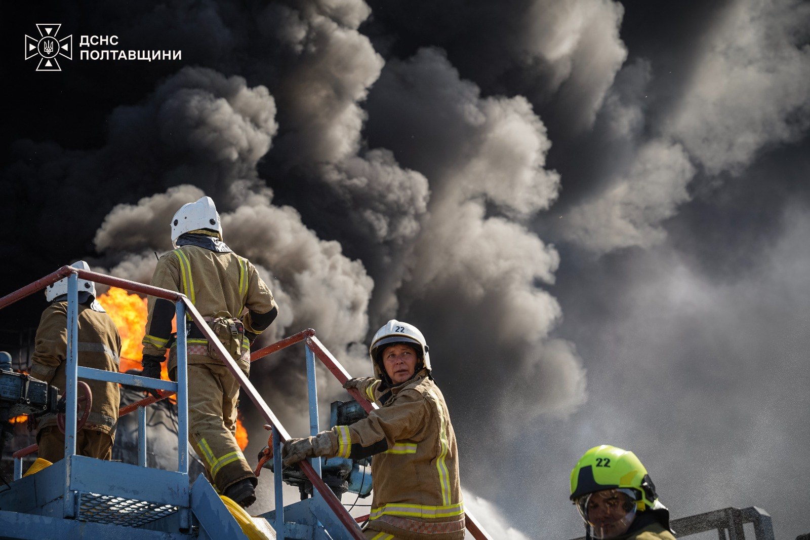 Троє пожежників на тлі густого чорного диму
