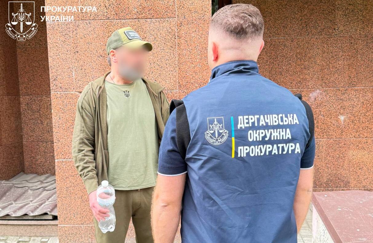 Чоловік стоїть перед співробітником прокуратури