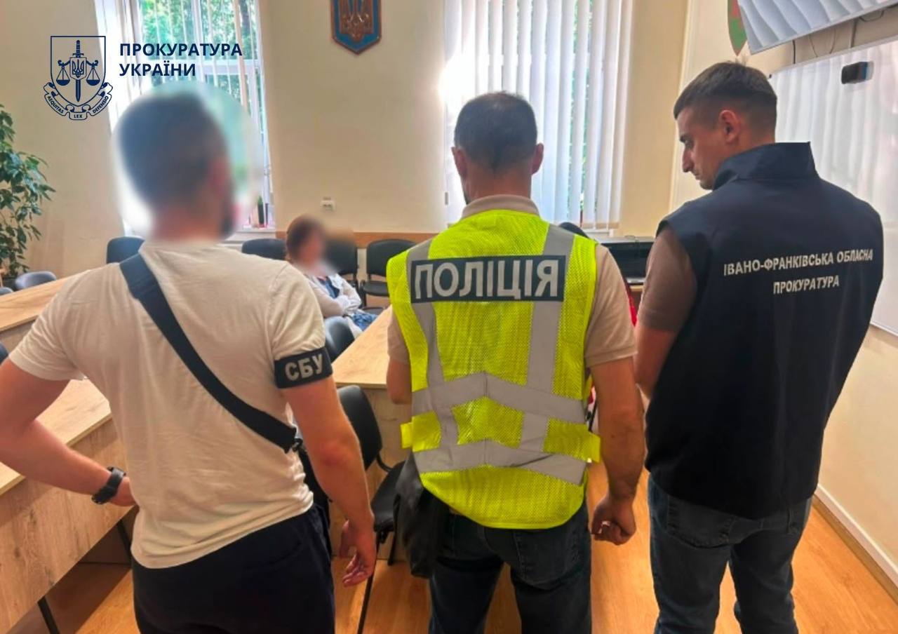 Викрита лікарки сидить перед правоохоронцями
