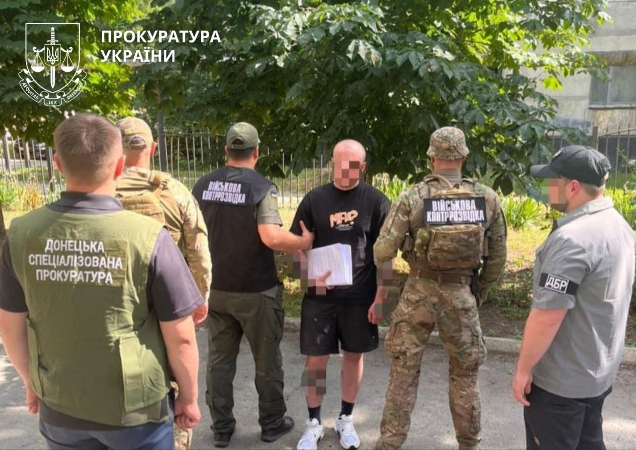 Затриманий стоїть перед правоохоронцями