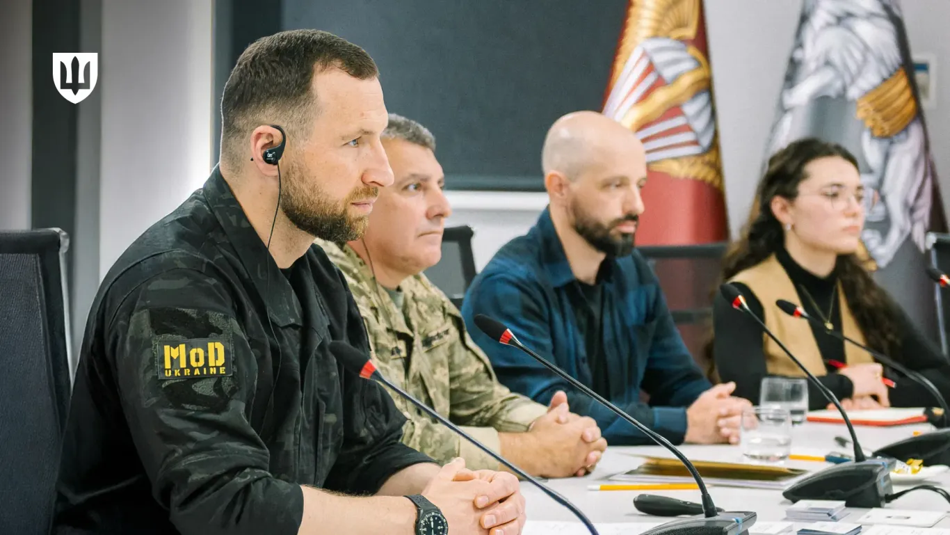Євгеній Хмара сидить на переговорах за столом