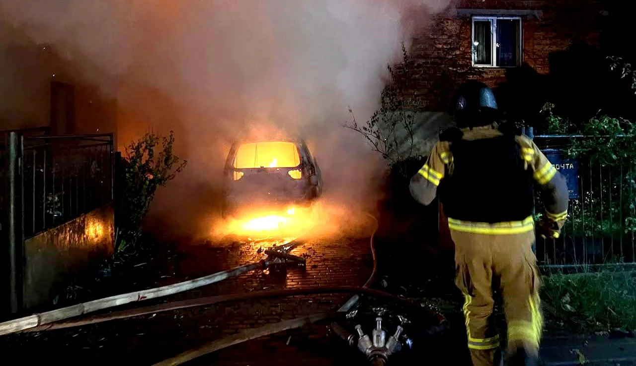 Пожежник біля палаючого авто